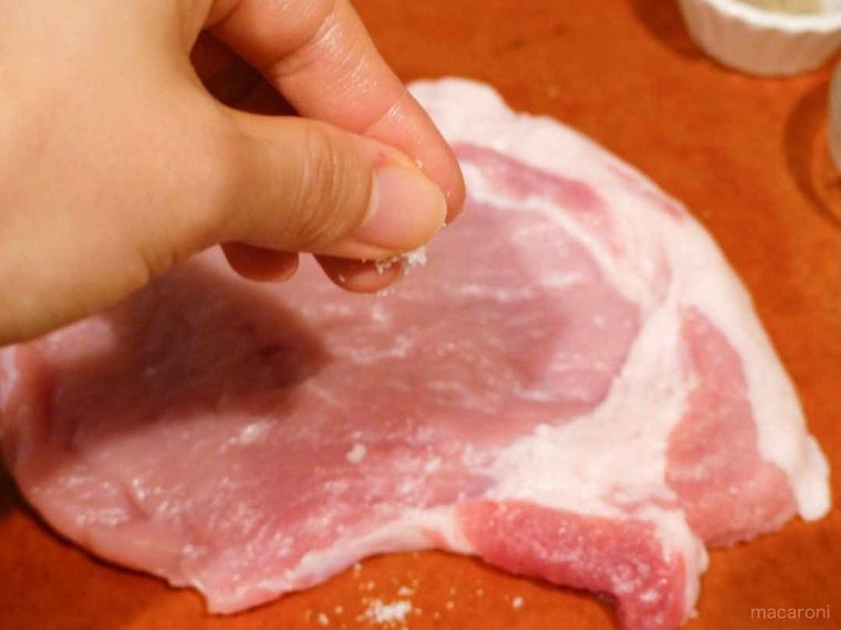 豚肉に塩胡椒する写真