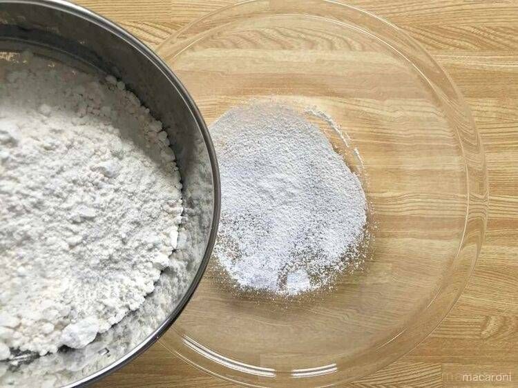 ベーキングパウダーが入ったボウルに小麦粉を入れる様子