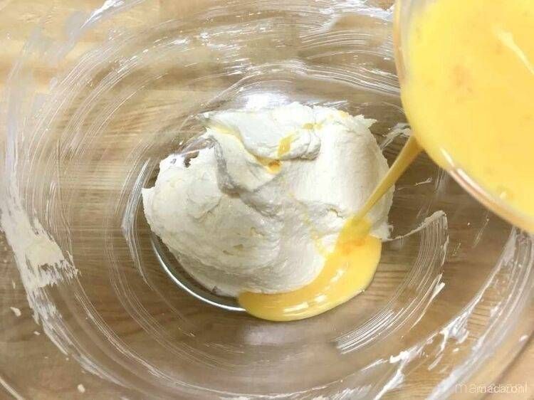クリーム状のバターに卵を加える様子