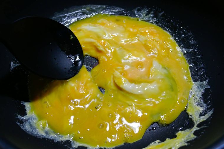 フライパンで卵を混ぜながら炒める様子
