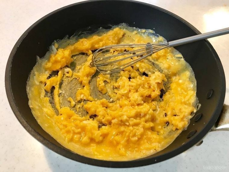 泡立て器を使って、フライパンで炒り卵を作っている様子