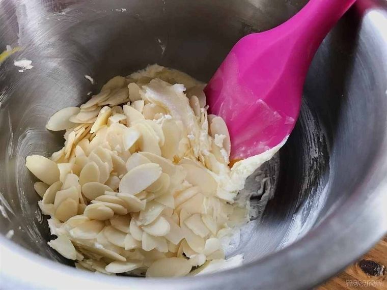 ボウルの中にアーモンドスライスを加え、ゴムベラで混ぜる様子