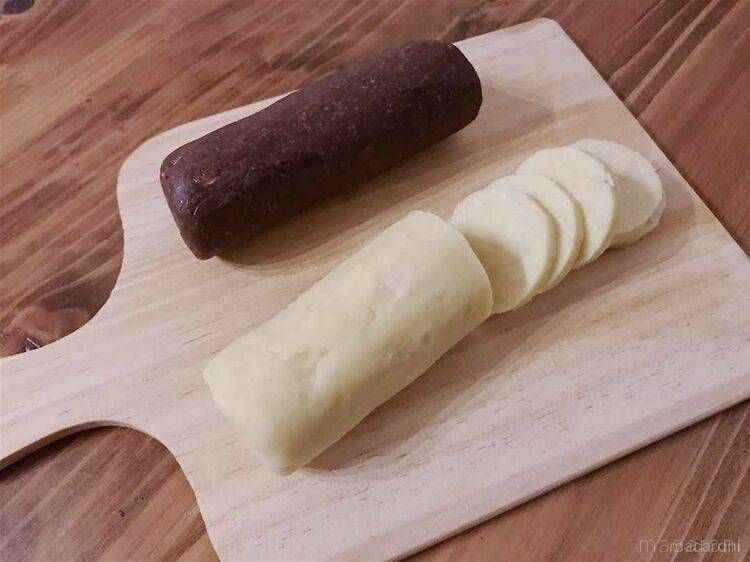 木製のカッティングボードの上でクッキー生地を切る様子