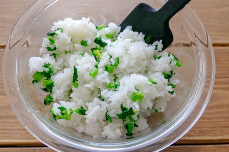 大根の葉とごはんをヘラで混ぜる様子