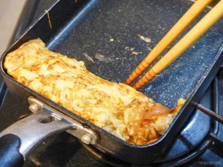 卵焼きを菜箸で巻いている様子
