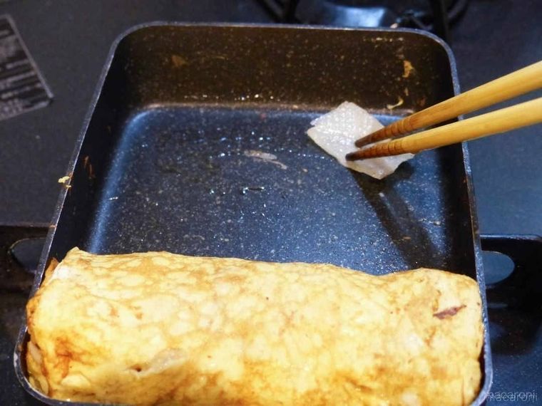 卵焼きが入ったフライパンに油を引いている様子