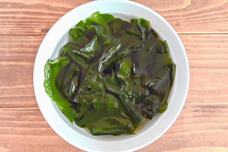 白いボウルに入った、水に入った乾燥わかめ