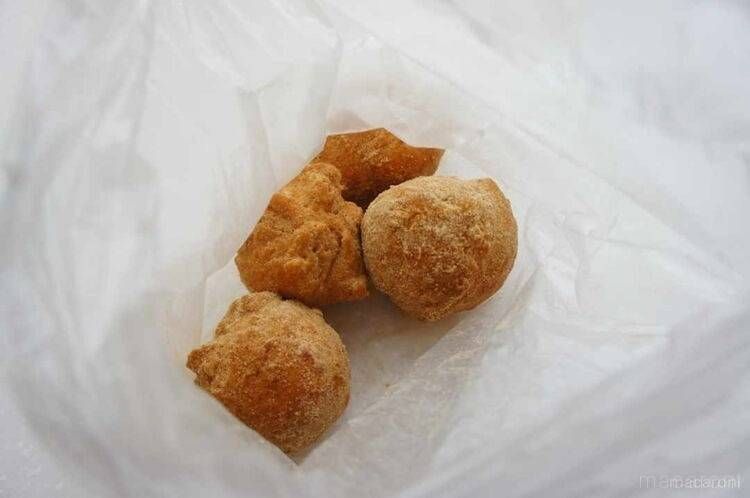 ポリ袋で豆腐ドーナツにきな粉をまぶしている様子