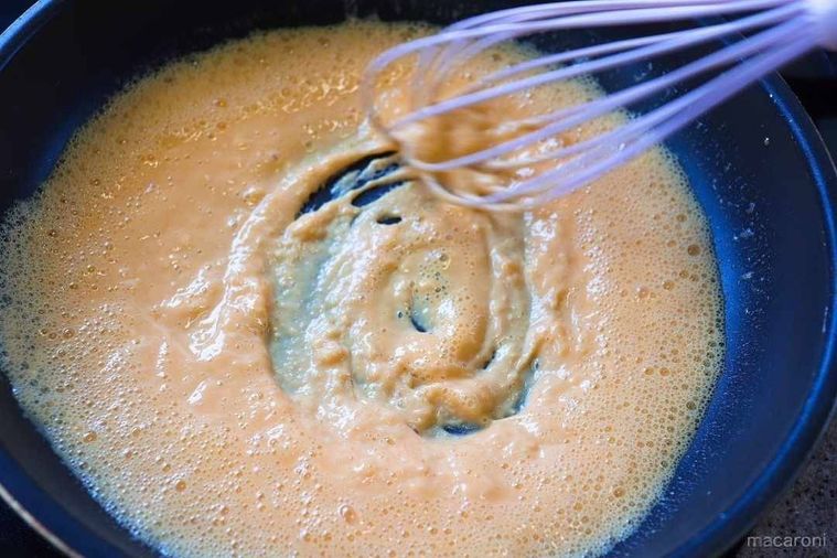 炒めたとき卵を泡だて器で混ぜる様子