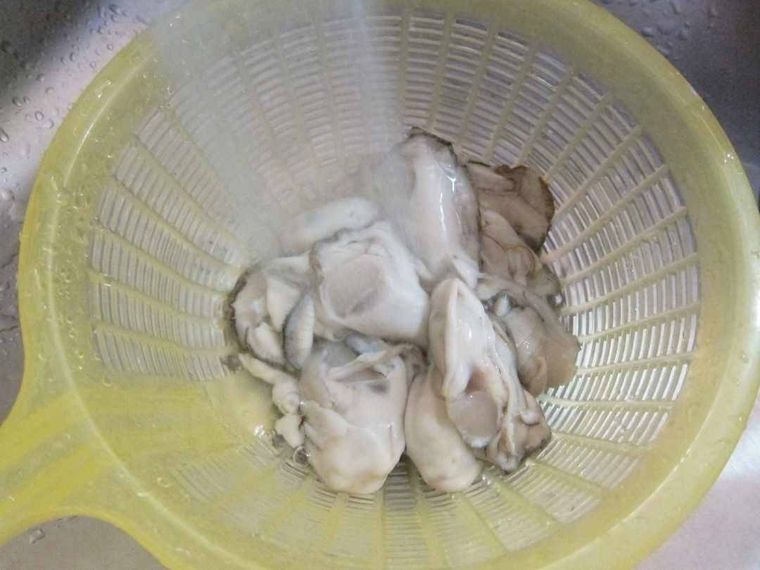 ザルに入っている牡蠣を流水で洗う