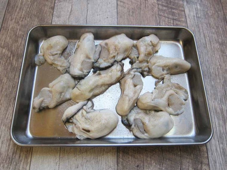 バットに並んでいる塩コショウをした牡蠣