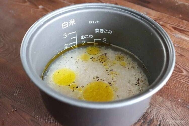 炊飯釜に塩とオリーブオイル、黒こしょうを入れた様子