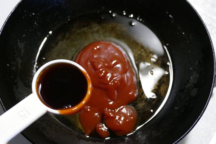 フライパンにケチャップとしょうゆを加える様子