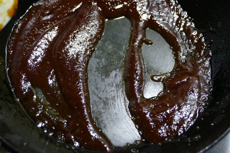 ソースが入っているフライパンの底をなぞって跡が残るのを確認する様子