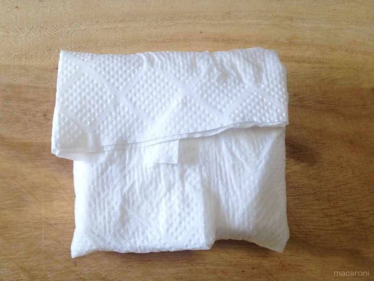 ゆでた厚揚げをキッチンペーパーで包み押さえれば、油抜きの完了