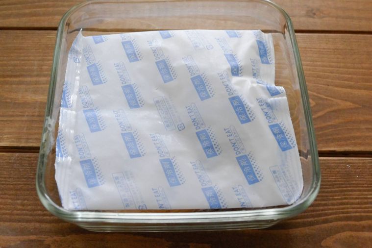 ガラス製の保存容器に保冷剤を重ねる様子