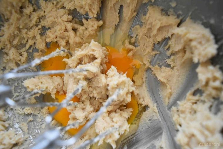 ボウルに入ったバターと砂糖を混ぜた生地に卵が入っている。