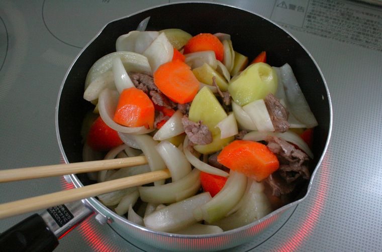 鍋で肉じゃがの具材を炒めている様子