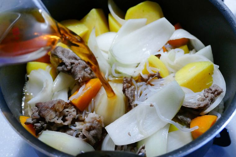 鍋にめんつゆを注ぎ入れる様子