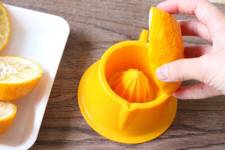 半分にカットしたゆずの果汁を絞っている様子