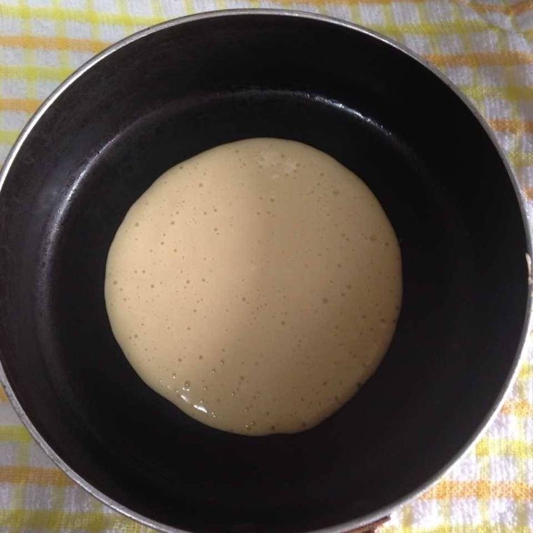 フライパンにお玉1杯分の生地を入れた様子