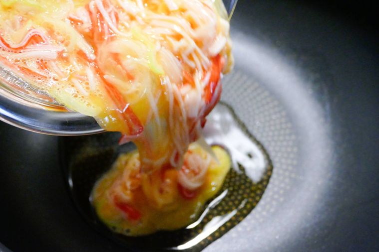 ごま油が入っているフライパンに卵液を流し入れる様子