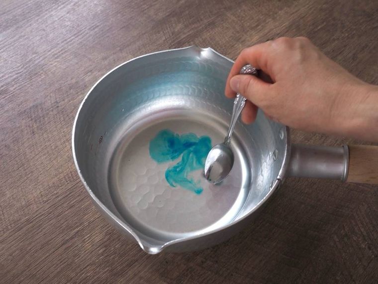 鍋に入った水に色粉を入れている様子
