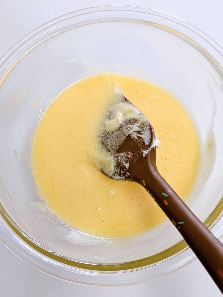 ガラスボウルの中に入ったバターと砂糖と卵とヘラ