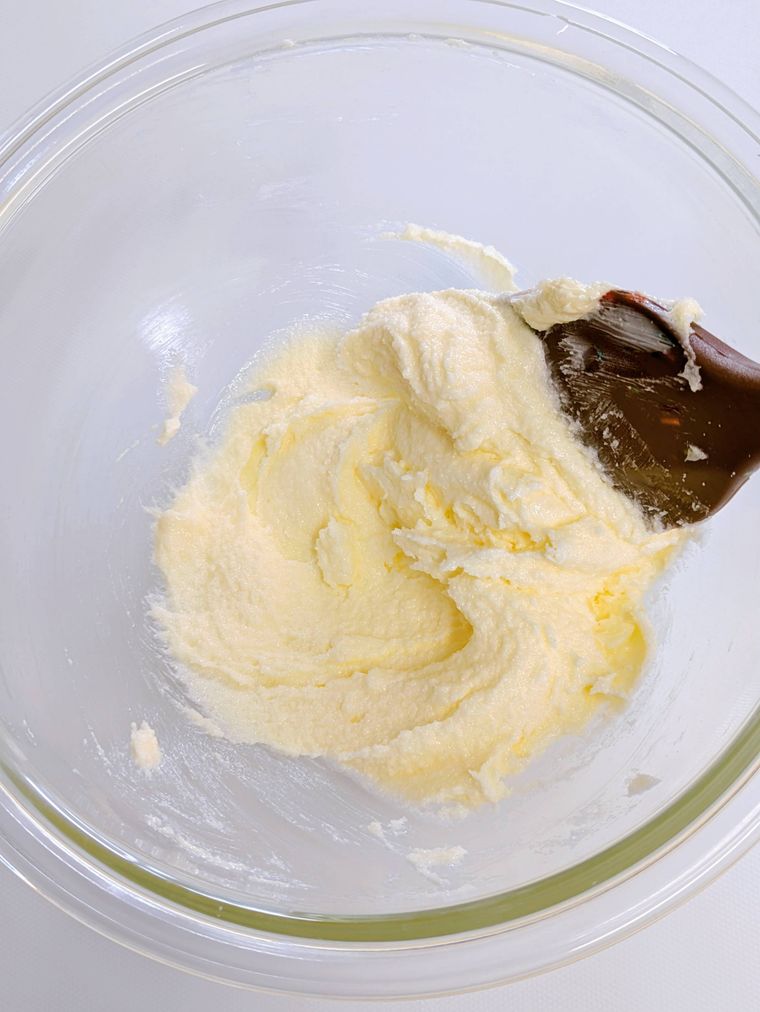 ガラスボウルの中に入ったバターと砂糖とヘラ