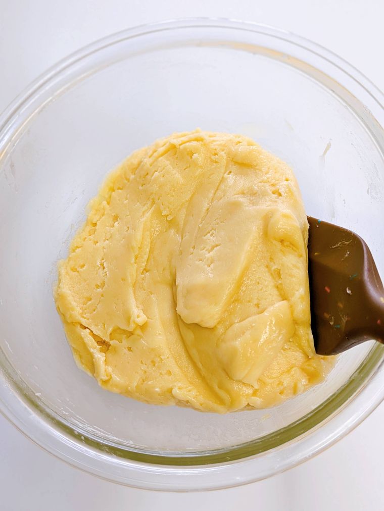 ガラスボウルの中に入ったクッキー生地とヘラ