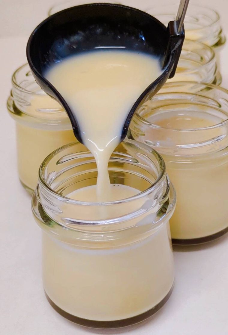 お玉でプリン液を器に注ぎ入れている所