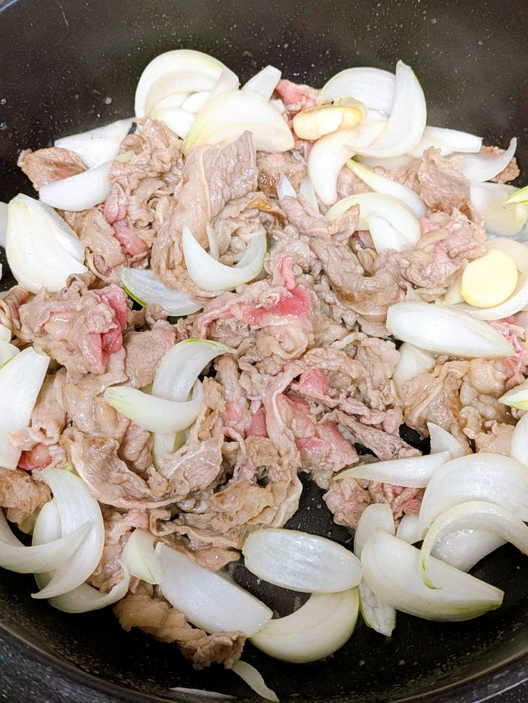 フライパンで牛肉、玉葱、しょうがを炒めているところ