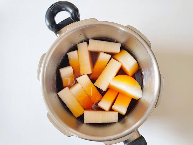 調味料が入った圧力鍋に大根を並べた様子