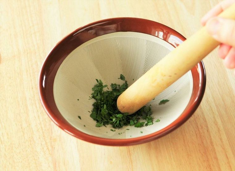 すり鉢の中ですりつぶされている木の芽の葉