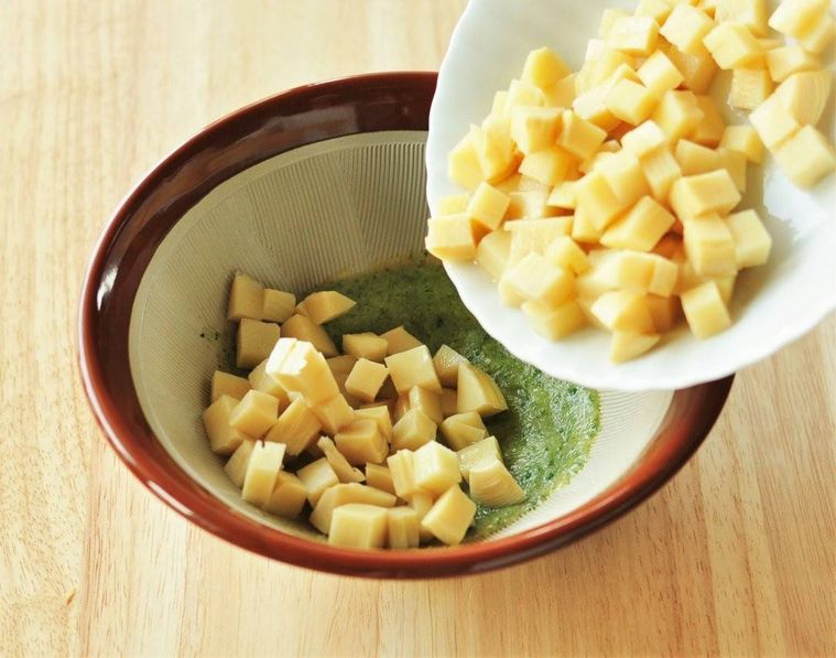 木の芽味噌が入ったすり鉢の中に下煮したたけのこが入れられている様子