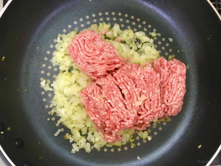 フライパンの中の炒め玉ねぎと生のひき肉