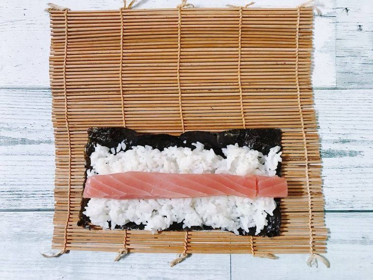 マグロをのせた巻きすの上の酢飯