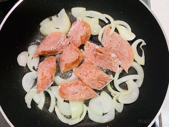 フライパンで炒めた玉ねぎに加えた、下ごしらえ済みの鮭