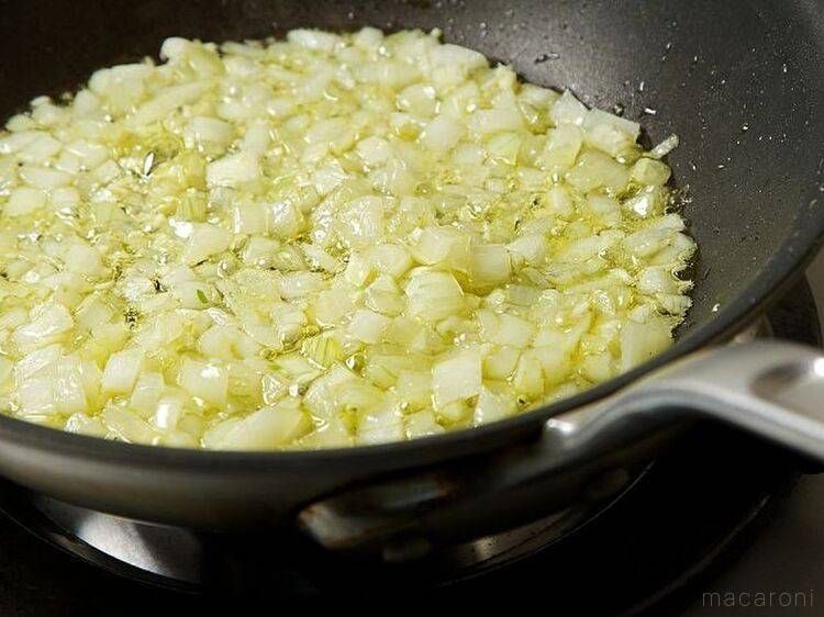 黒いフライパンで、にんにくと玉ねぎを加熱している様子