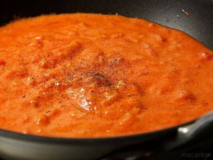 黒いフライパンに入った、トマトクリームソース