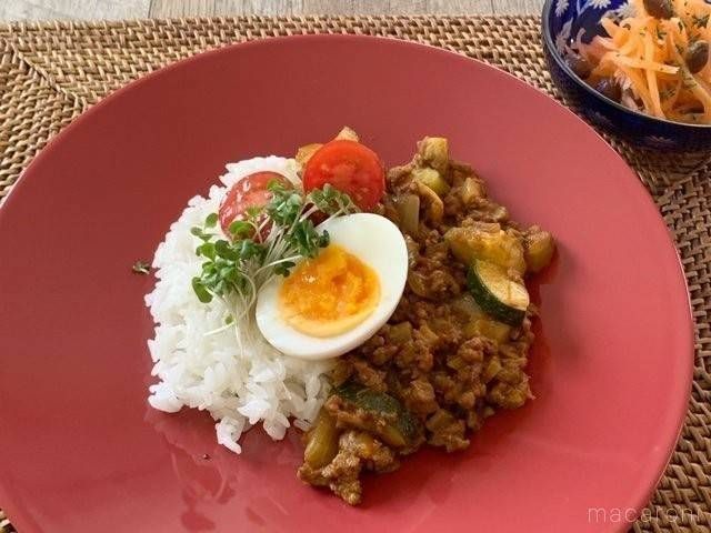 ゆで卵とミニトマトがトッピングされているズッキーニのドライカレー