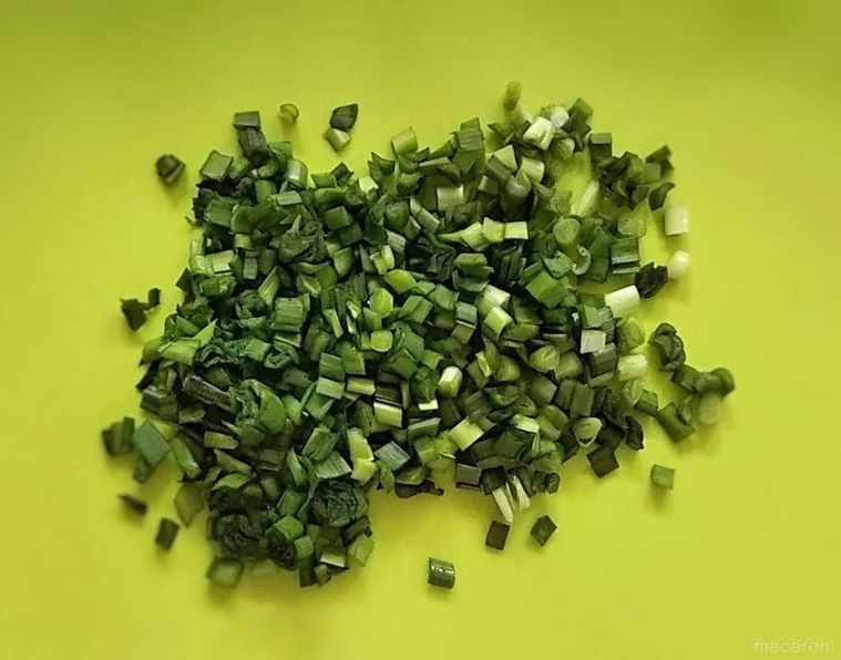 グリーン色のまな板の上でみじん切りにされたニラ