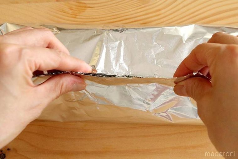 アルミホイルの端を持ち上げるようにして閉じている様子