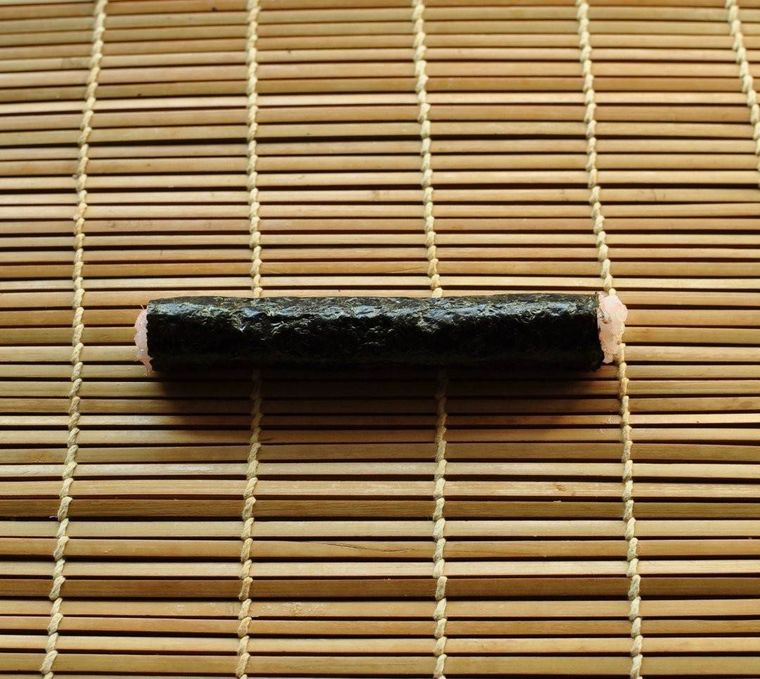 巻きすの上に置かれた細い海苔巻き