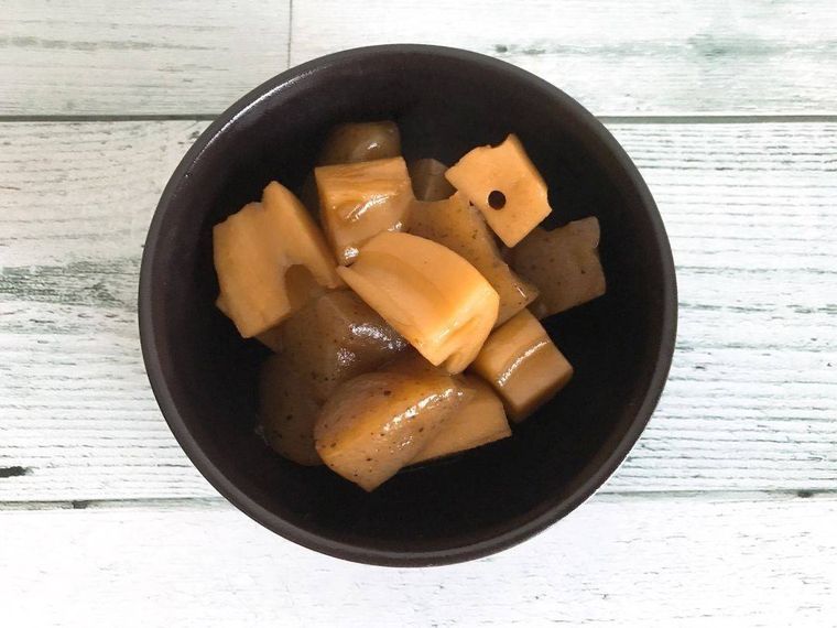 黒い器に盛ったれんこんとこんにゃくの甘辛煮
