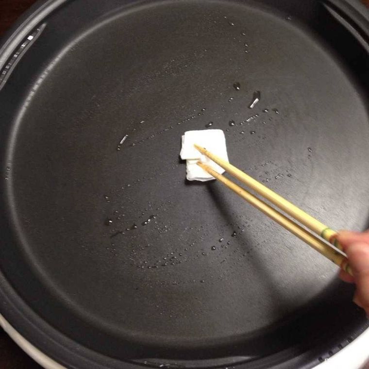 フライパンの中の油を染み込ませたキッチンペーパー