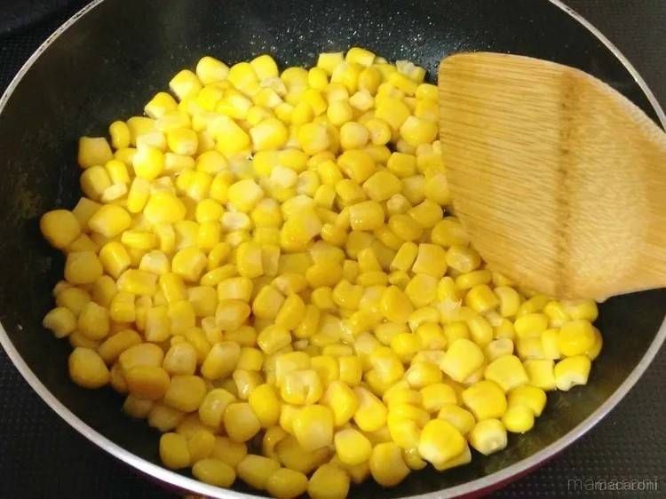 コーンを加えて炒める様子