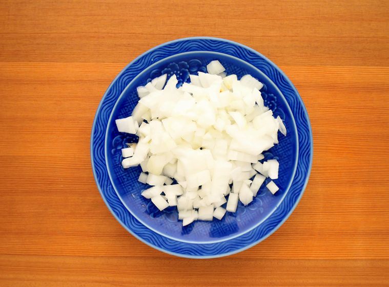 青い皿に並べた、みじん切りにした玉ねぎ