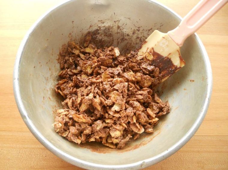 チョコレート、コーンフレーク、ビスケットをゴムベラで混ぜ合わせている様子