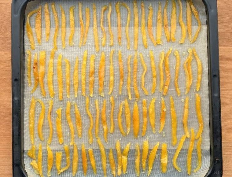 クッキングシートを敷いた天板に並べた、砂糖で煮たゆずの皮